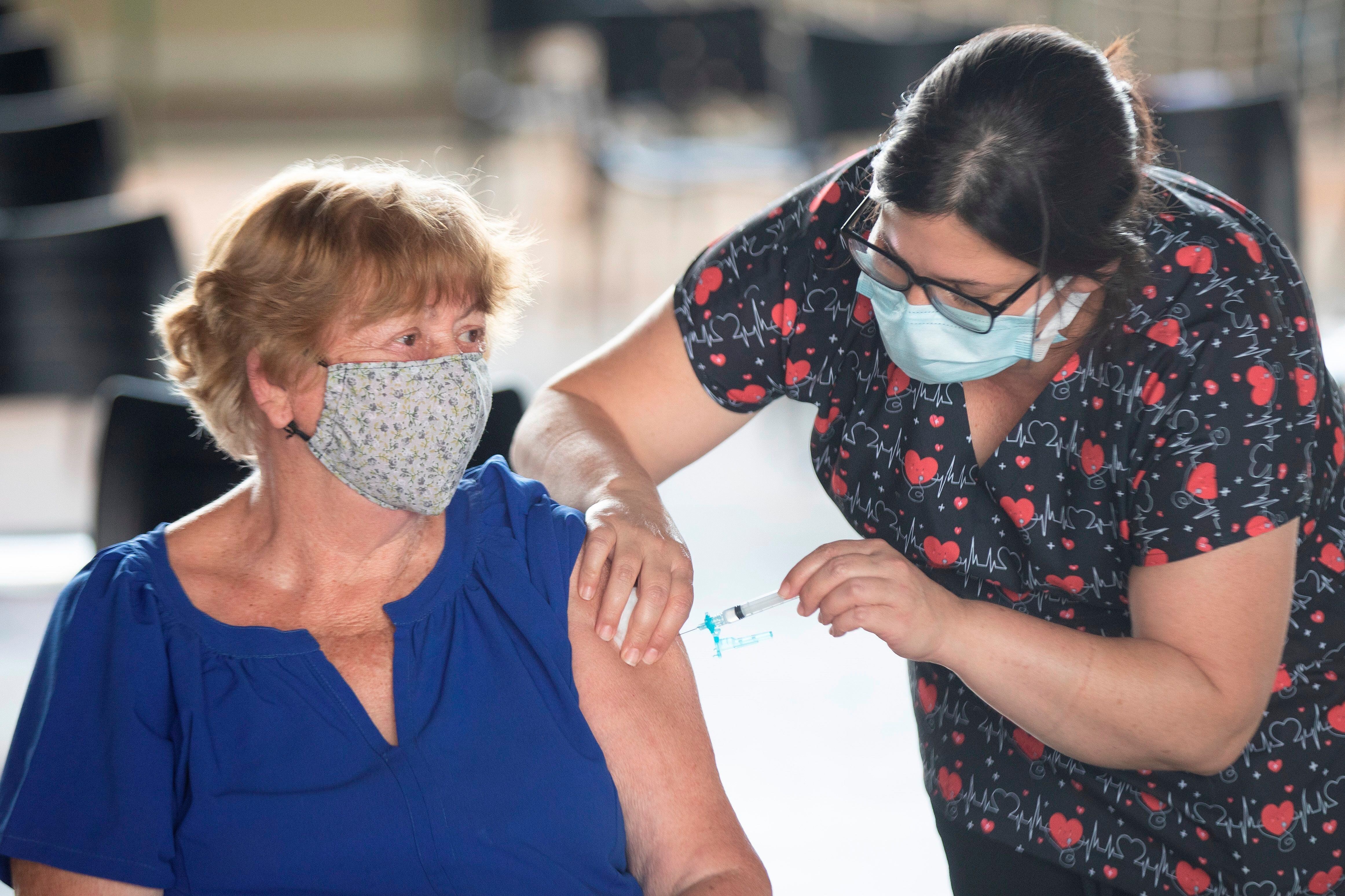 Una mujer recibe la vacuna contra el COVID-19 hoy, en Brasilia (Brasil). EFE/Joédson Alves 