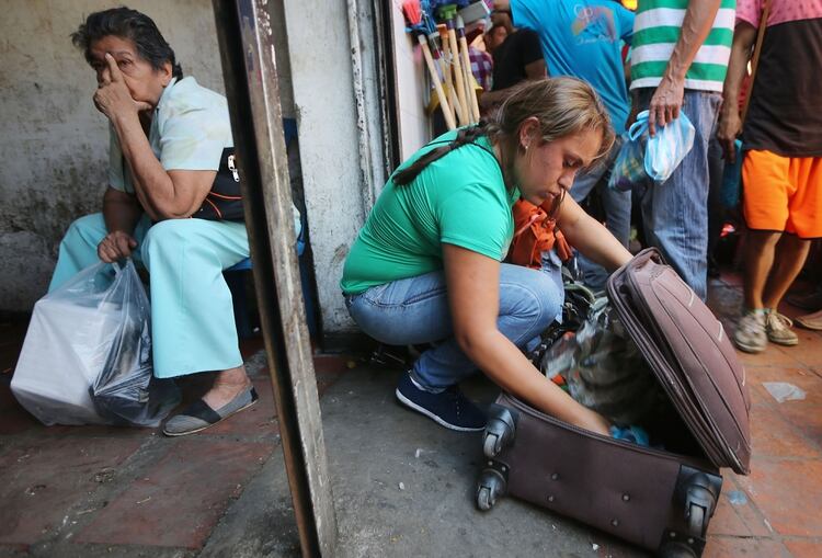 Gracy (derecha), una migrante venezolana, empaca comida que ha comprado después de hacer un viaje de 14 horas desde su ciudad natal (Mario Tama/Getty Images)