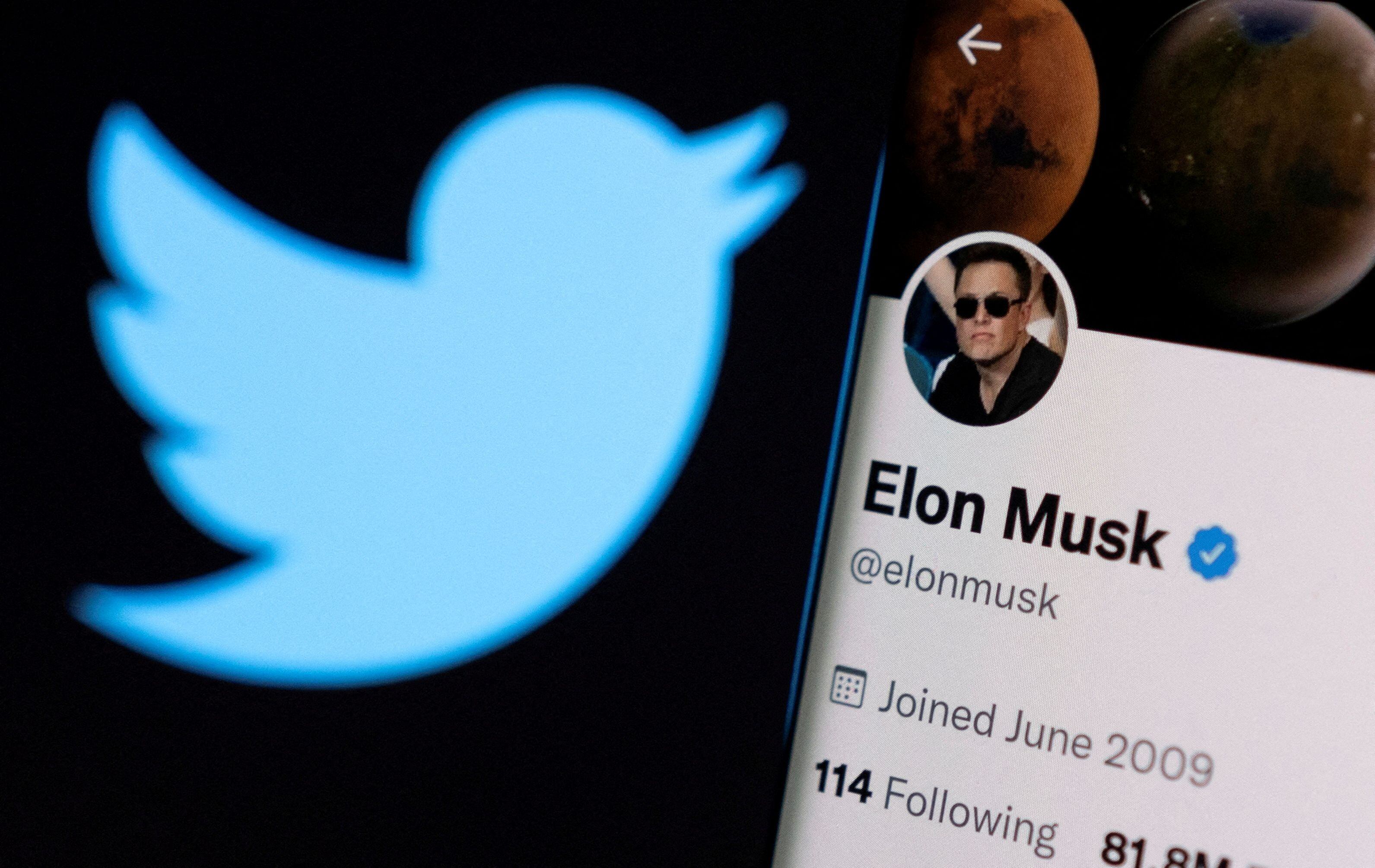 La cuenta de Twitter de Elon Musk se ve en un teléfono inteligente frente al logotipo de Twitter en esta ilustración tomada el 15 de abril de 2022 (REUTERS/Dado Ruvic/archivo)