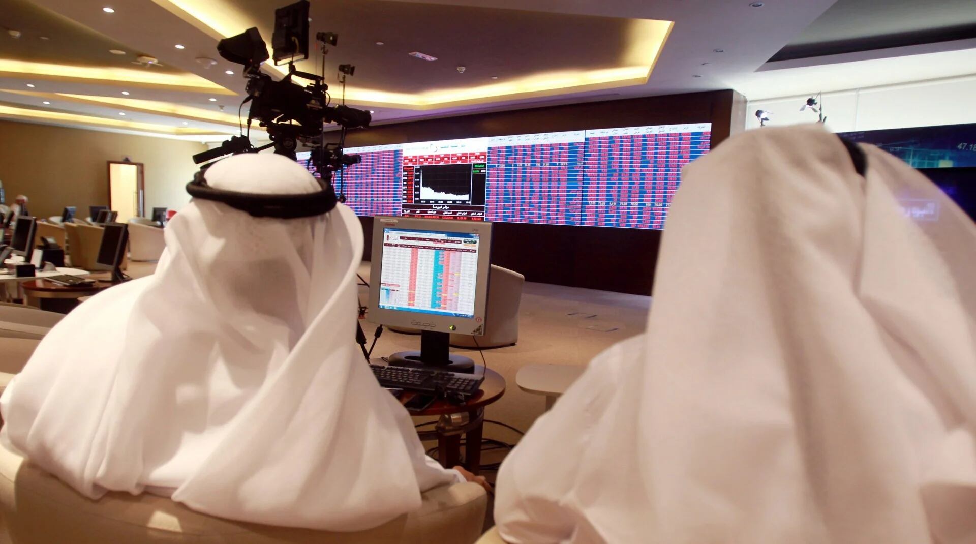 Agentes financieros monitorean el movimiento de las acciones en la Bolsa de Doha (Reuters)