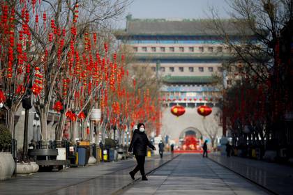 Una mujer camina con barbijo por las calles de Beijing (REUTERS/Carlos Garcia Rawlins)