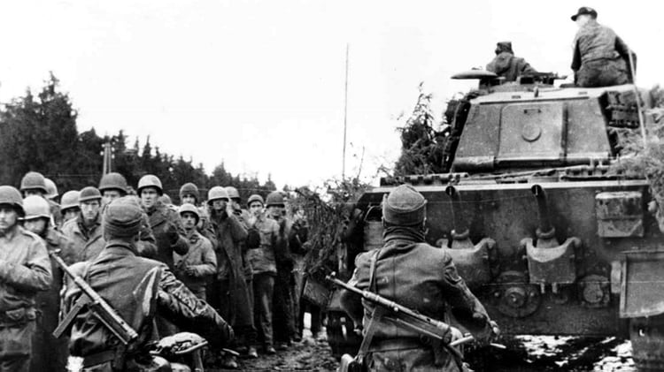 En esta imagen de archivo, soldados alemanes junto a un tanque Pzkfw Tiger Ausfb B., o Tiger II, vigilan a tropas estadounidenses capturadas en los primeros días de la batalla