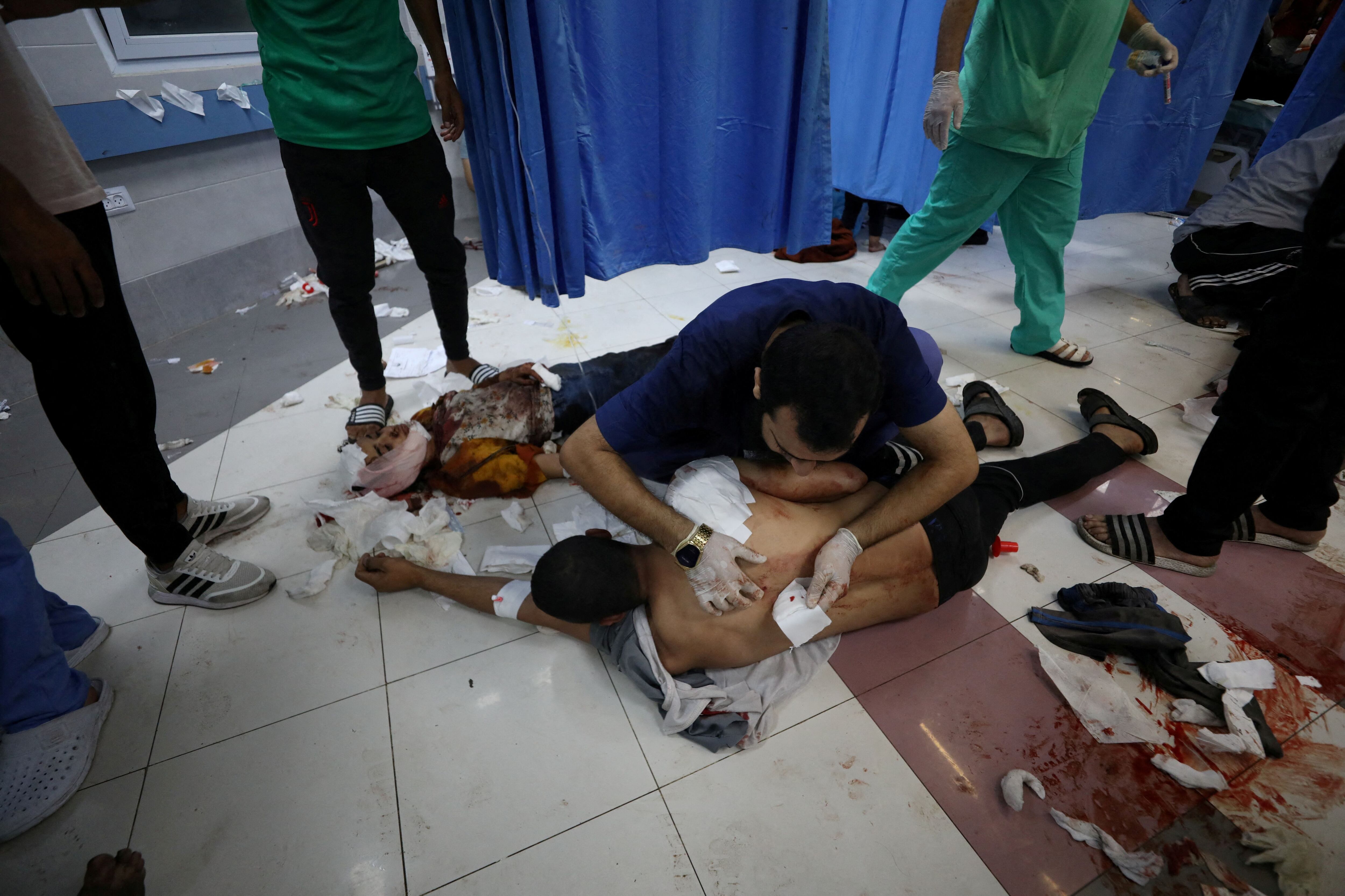SENSITIVE MATERIAL. THIS IMAGE MAY OFFEND OR DISTURB    Injured people are assisted  after Israeli air strike hit At Al-Ahli Hospital, according to Gaza Health Ministry ,in Gaza City, Gaza Strip, October 17, 2023. REUTERS/Mohammed Al-Masri
