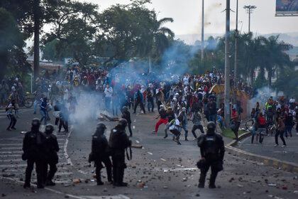 Manifestantes se enfrentan a miembros del ESMAD durante una jornada de protestas en contra de la reforma tributaria propuesta por el gobierno de Iván Duque, el 29 de marzo de 2021, en Cali (Colombia). EFE/Ernesto Guzmán Jr

