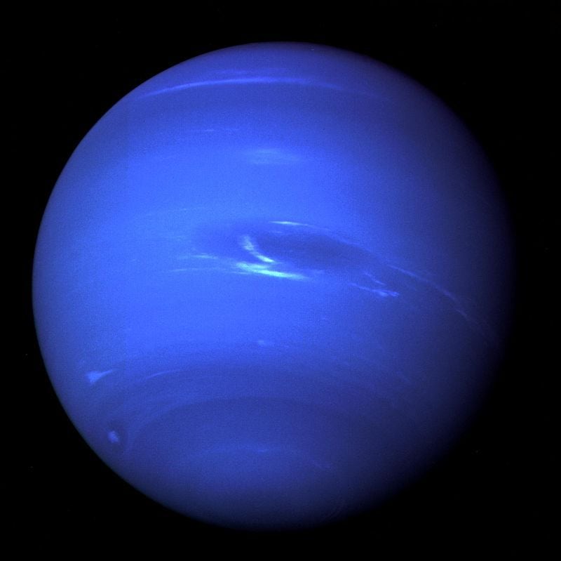 Imagen de la "Gran Mancha Oscura", una tormenta en la atmósfera, y la brillante mancha de nubes celestes que acompaña a la tormenta en el planeta Neptuno, tomada por la nave espacial Voyager 2 de la NASA a menos de cinco días de su punto más cercano al planeta, el 25 de agosto de 1989. ( NASA/JPL-Caltech/Handout via REUTERS.)