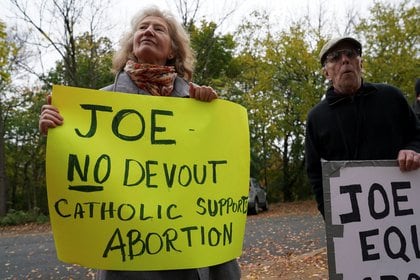 Una manifestante sostiene una pancarta con un mensaje anti aborto mientras Joe Biden asiste a una misa en Wilmington, Delaware. REUTERS/Kevin Lamarque