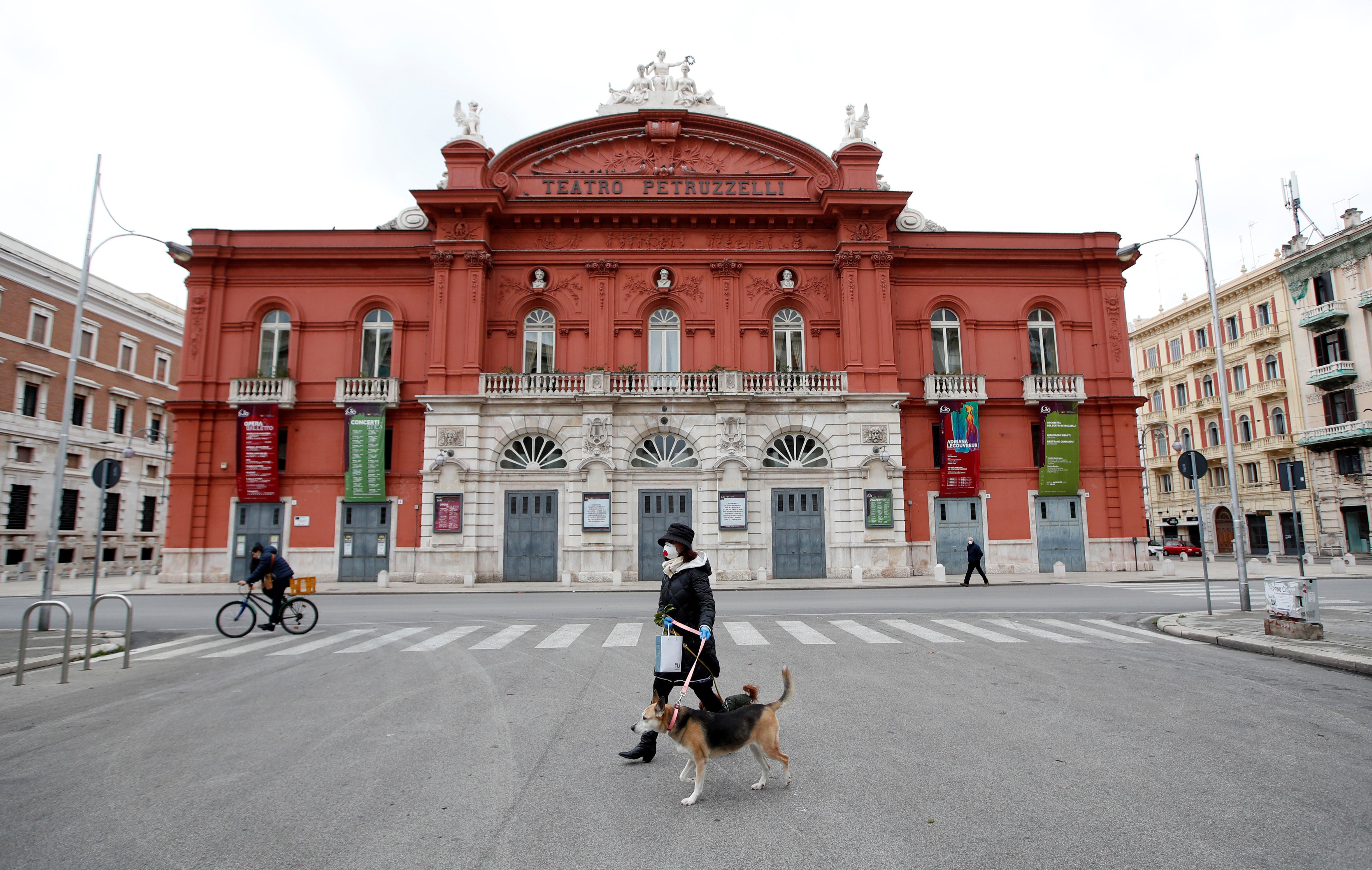 Una mujer pasea a su perro en Bari, Italia (Reuters)