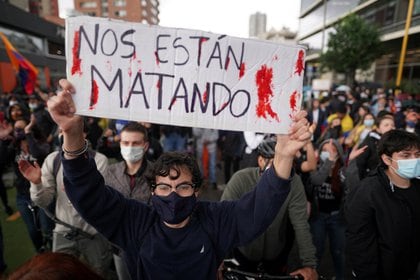 Un manifestante sostiene un cartel en el que se lee "Nos están matando" durante una protesta en Bogotá, Colombia, el 4 de mayo de 2021. REUTERS/Nathalia Angarita