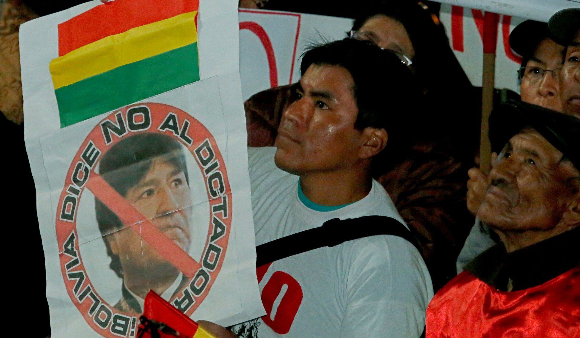Un manifestante boliviano que se opone a la reelección indefinida sostiene un cártel con la cara de Evo Morales y la leyenda "Bolivia le dice no al dictador" (REUTERS/David Mercado)