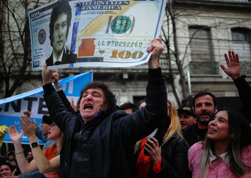 El candidato presidencial argentino Javier Milei, del partido La Libertad Avanza, sostiene un póster que representa el billete de un dólar con su rostro, durante un acto de campaña en La Plata, Buenos Aires, Argentina, el 12 de septiembre de 2023. REUTERS/Agustin Marcarian