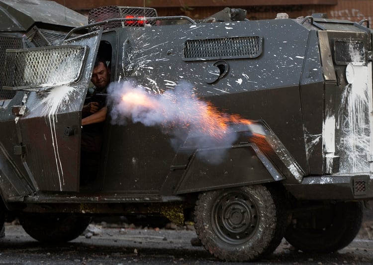 Un carabinero dispara desde un blindado (AFP)