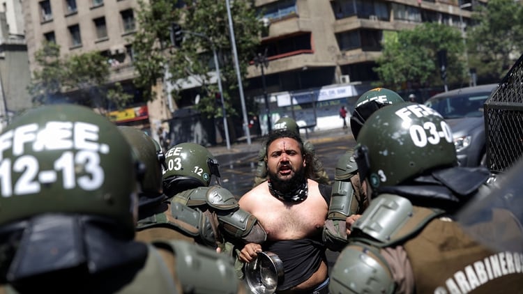 Carabineros se llevan detenido a un manifestante (Reuters)