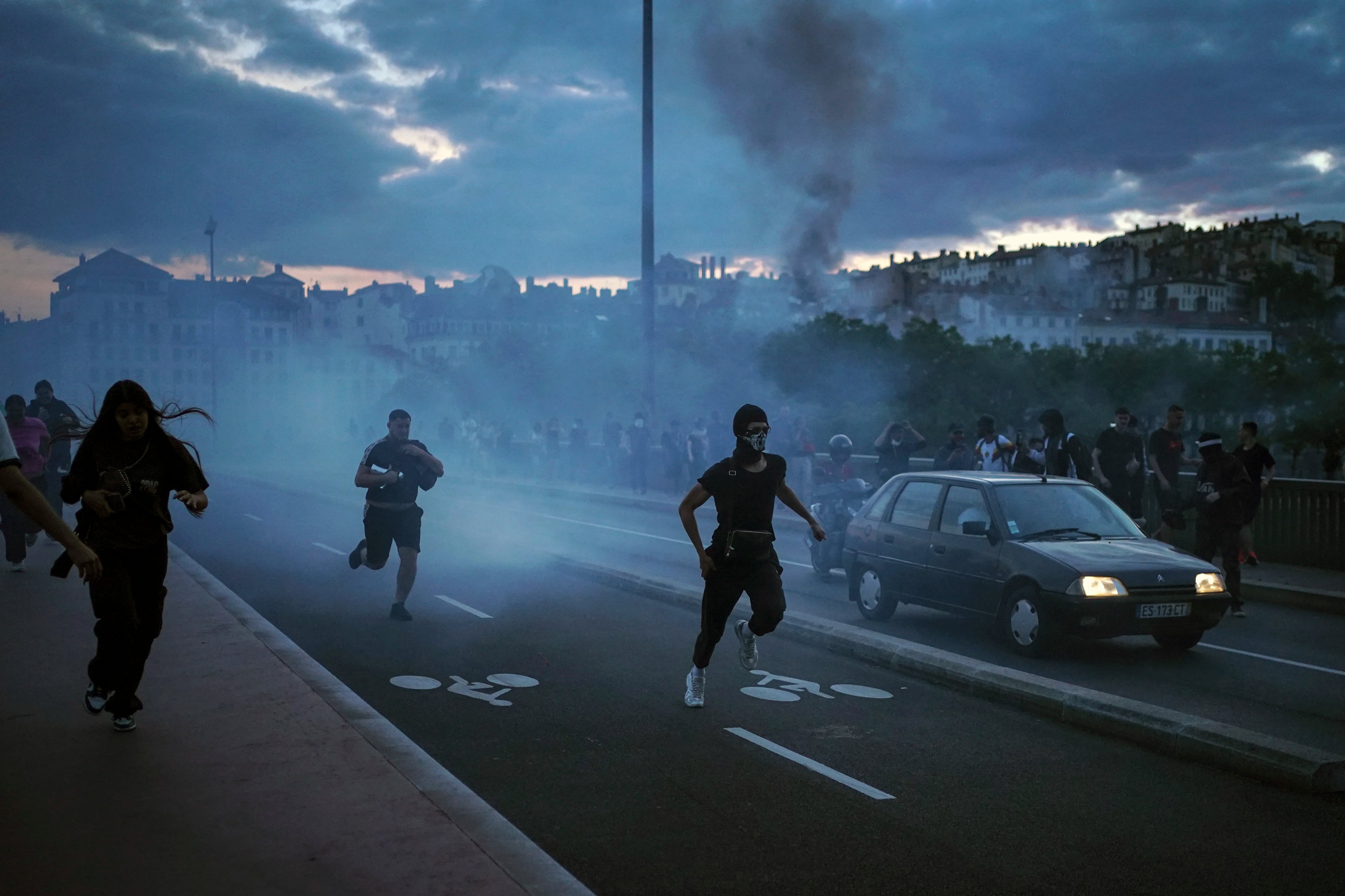 Varias personas salen corriendo durante disturbios con la policía en el centro de Lyon. (AP Foto/Laurent Cipriani)