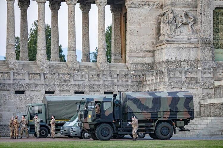 Militares italianos en el cementerio de Bérgamo después de que el ejército fue desplegado para transportar ataúdes del cementerio a las provincias vecinas, después de que el cementerio se viera abrumado el 18 de marzo de 2020 por el brote del coronavirus (COVID-19), en Italia (Sergio Agazzi. Fotogramma via REUTERS)