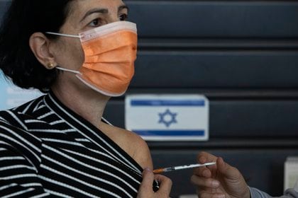 Una mujer recibe una vacuna contra el COVID-19 en Israel. (AP Photo/Sebastian Scheiner)