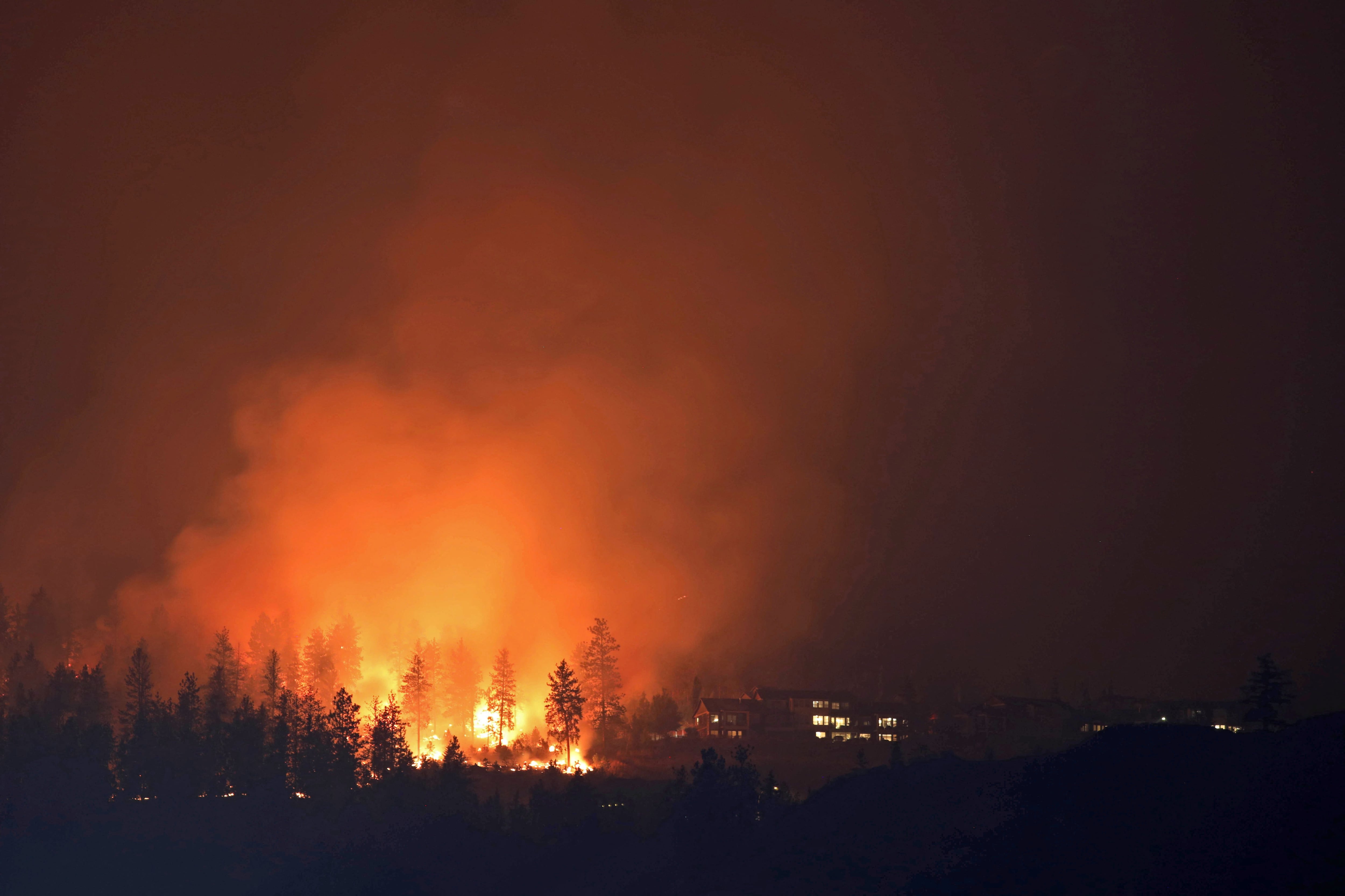 The McDougall Creek wildfire burns next to houses in the Okanagan community of West Kelowna, British Columbia, Canada, August 19, 2023. REUTERS/Chris Helgren