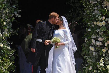 El príncipe Harry, nieto de Isabel II de Inglaterra, besaba a su esposa Meghan Markle a la salida de la capilla de San Jorge, en el castillo de Windsor, tras contraer matrimonio. Era el 18 de mayo de 2018 (EFE)