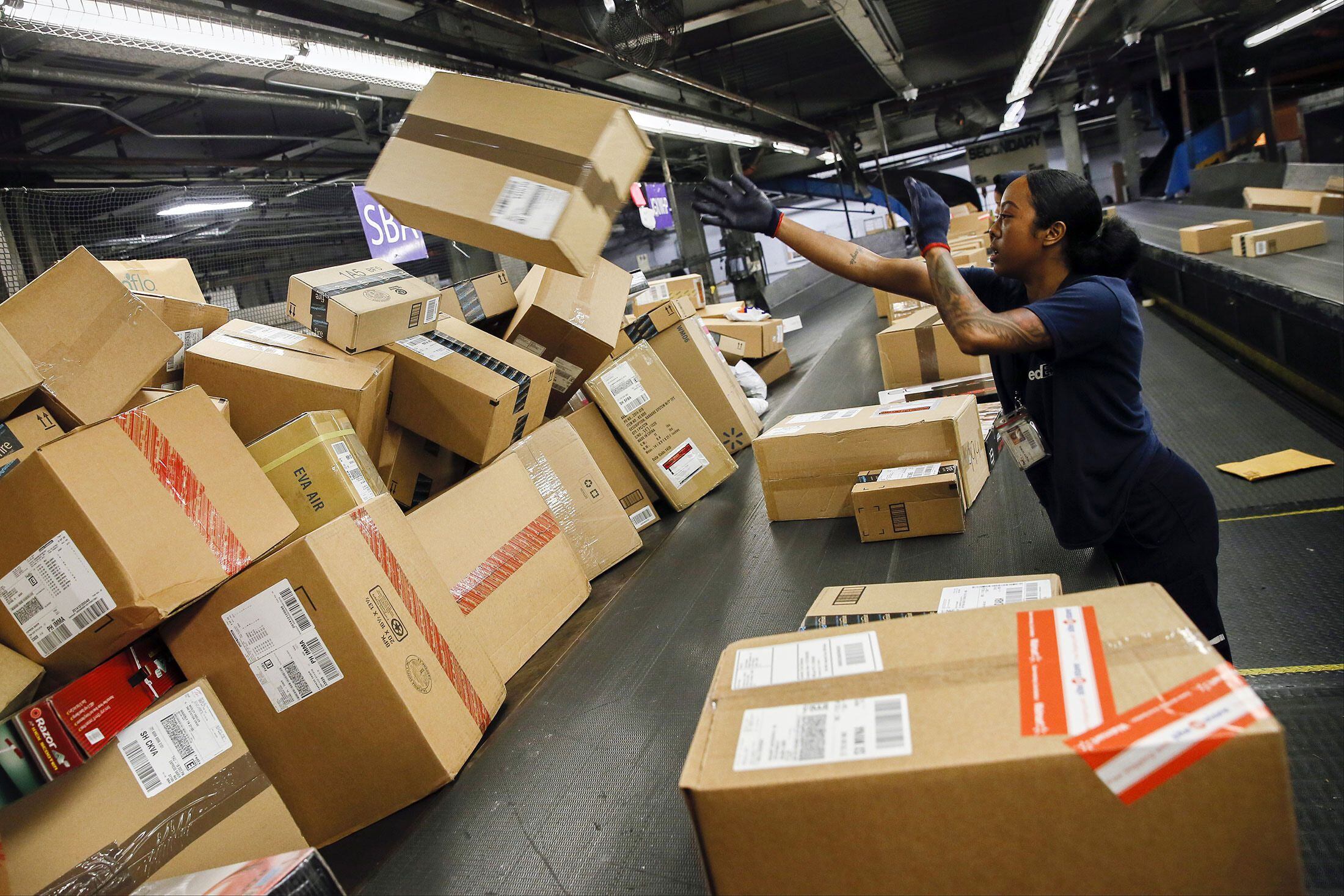 An employee sorts packages inside the FedEx Corp. distribution hub at Los Angeles International Airport on Dec. 15, 2014. MUST CREDIT: Bloomberg photo by Patrick T. Fallon.