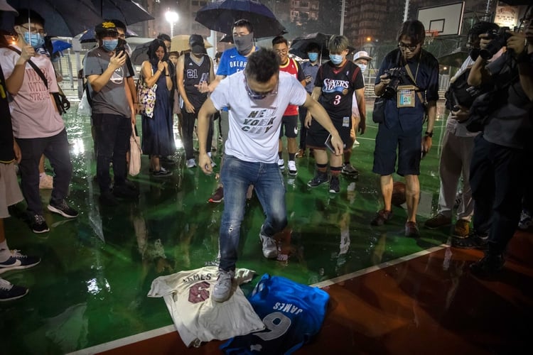 Un fanático chino pisotea una camiseta de LeBron James a modo de protesta en Hong Kong (AP)