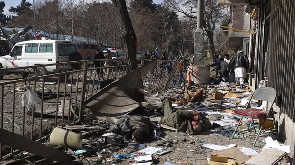 Voluntarios afganos cargan cuerpos tras la explosión frente al antiguo Ministerio del Interior en Kabul (AFP)