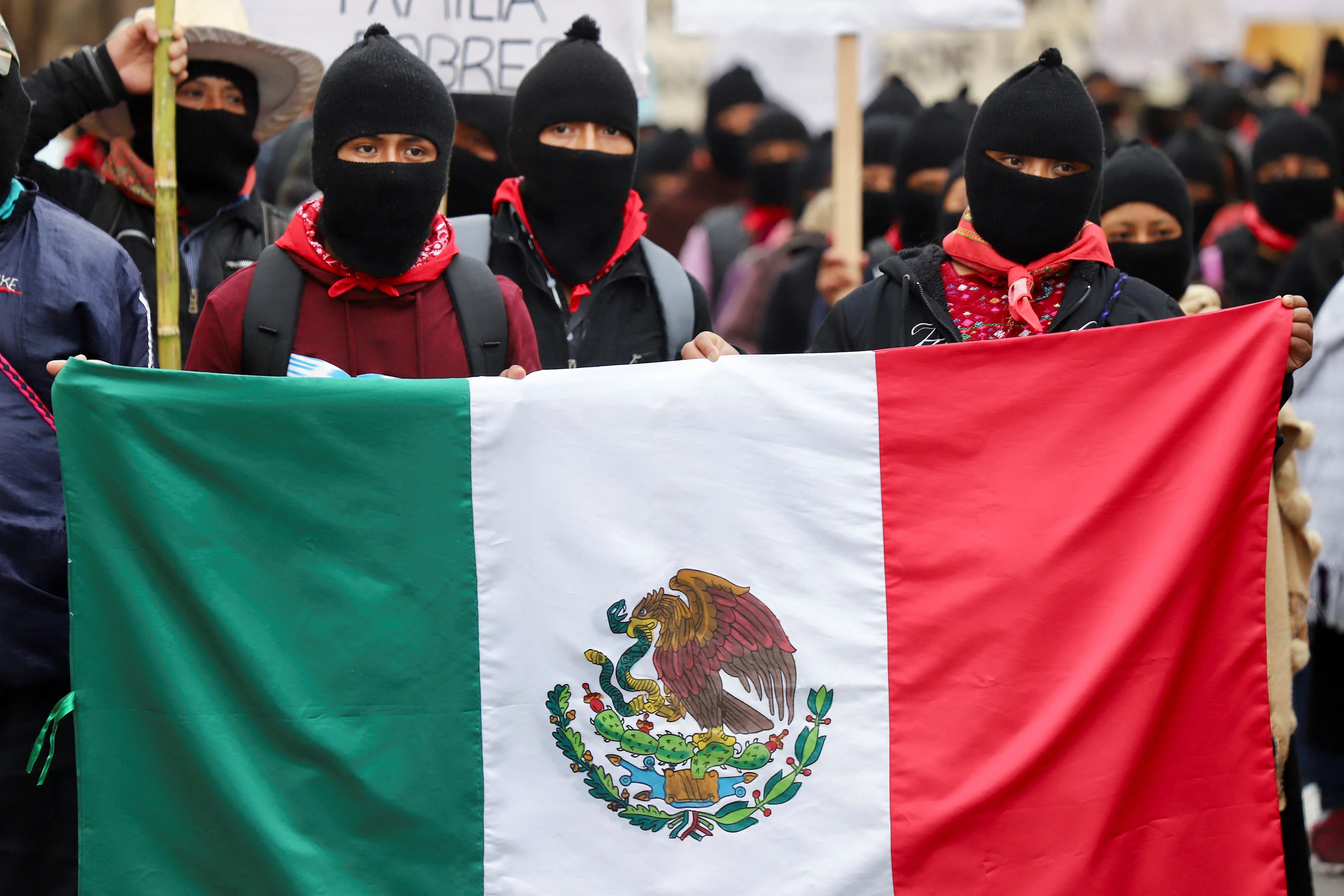 People hold a Mexican flag during a Zapatista National Liberation Army (EZLN) protest against war and capitalism, following Russian invasion of Ukraine, in San Cristobal de las Casas, Chiapas, Mexico March 13, 2022. REUTERS/Jacob Garcia