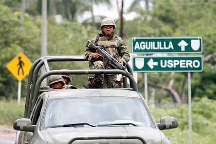 Mexican soldiers drive on a road near the town of Aguililla, Mexico, Wednesday, July 24, 2013 (AP)