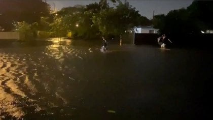 People walk in floodwaters caused by Storm Eta in Fort Lauderdale, Florida, U.S. in this still frame picture obtained from social media video dated November 8, 2020. MORGAN SHATTUCK /via REUTERS THIS IMAGE HAS BEEN SUPPLIED BY A THIRD PARTY. MANDATORY CREDIT. NO RESALES. NO ARCHIVES.  MUST CREDIT MORGAN SHATTUCK. MUST ON SCREEN COURTESY MORGAN SHATTUCK.