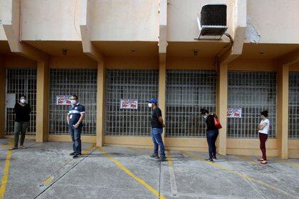 Imagen de archivo. Personas mantienen distancia social mientras esperan para hacerse una prueba de detección del coronavirus afuera de un laboratorio en Tegucigalpa, Honduras. 12 de junio de 2020. REUTERS/Jorge Cabrera