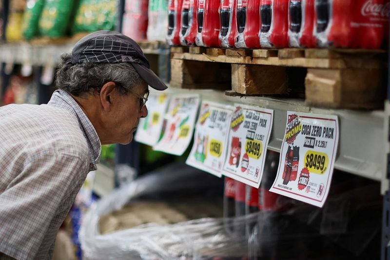 Un hombre chequea el precio de las gaseosas en un supermercado, mientras Argentina lucha con una inflación que se encamina al 200% en Buenos Aires, Argentina, el 13 de diciembre de 2023. REUTERS/Agustin Marcarian