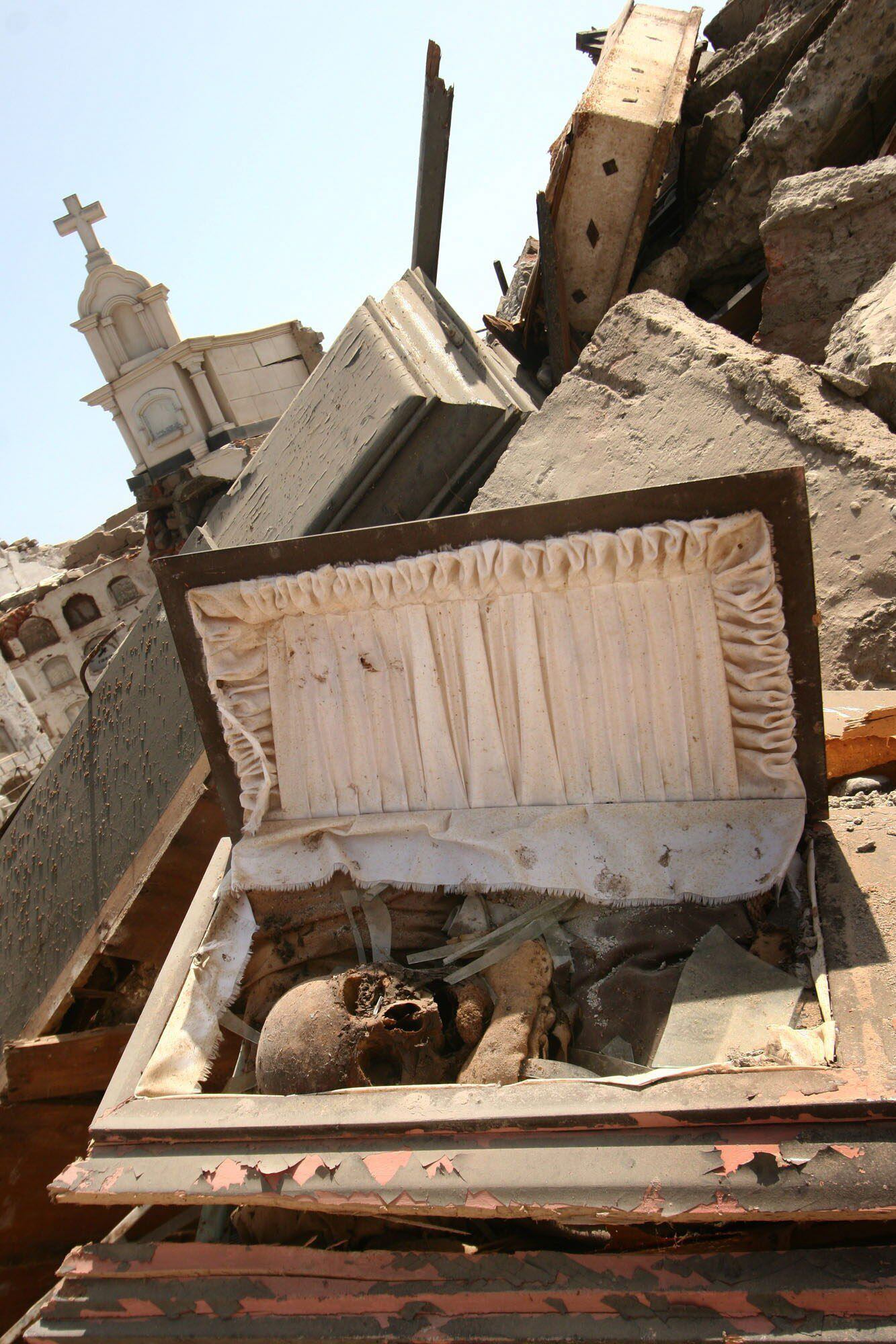 Ataúdes con cuerpos quedaron al descubierto tras la destrucción de la mayoría de los pabellones del cementerio de Pisco por el terremoto. (EFE)