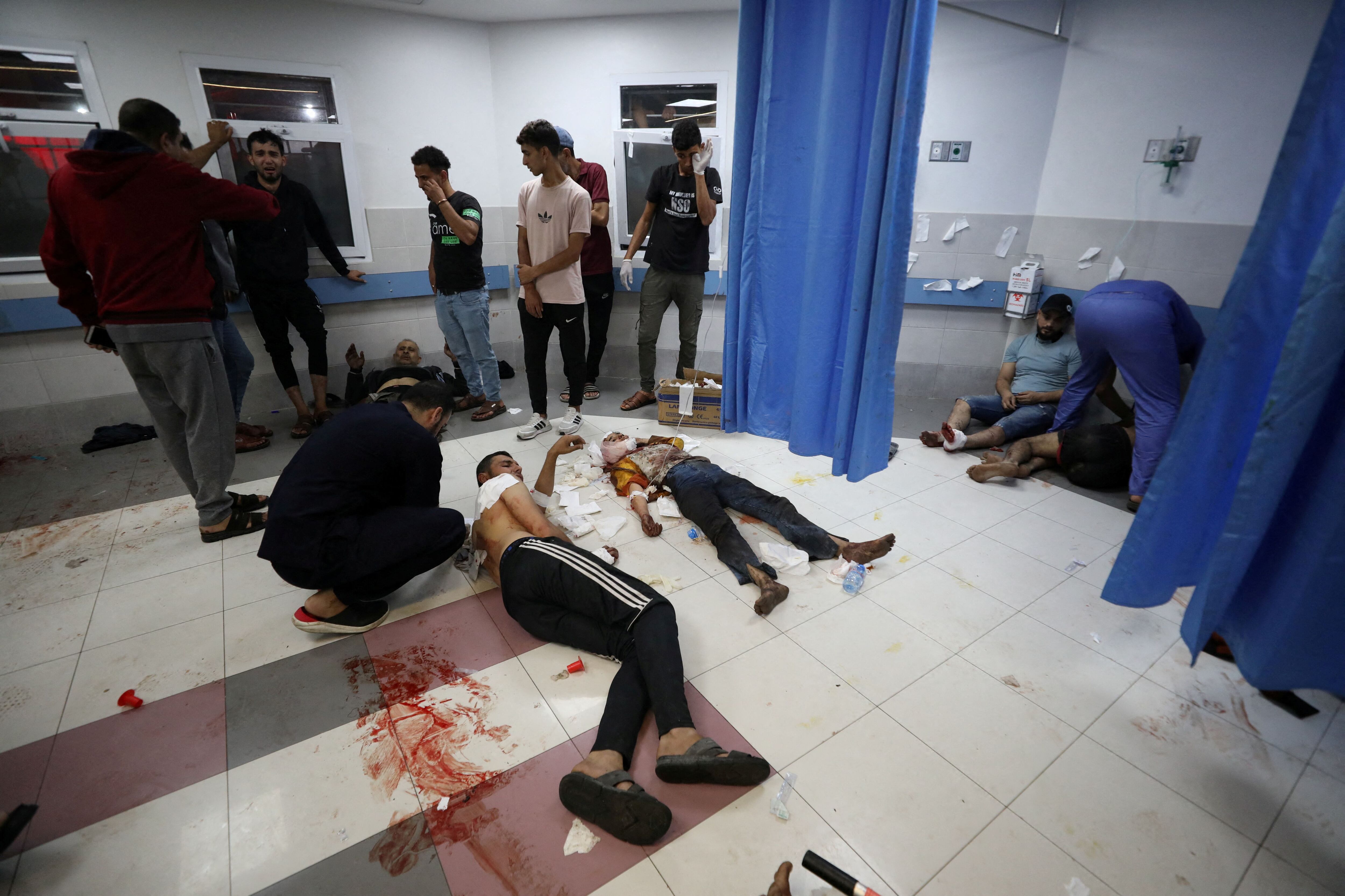 SENSITIVE MATERIAL. THIS IMAGE MAY OFFEND OR DISTURB    Injured people are assisted after Israeli air strike hit At Al-Ahli Hospital, according to Gaza Health Ministry in Gaza City, Gaza Strip, October 17, 2023. REUTERS/Mohammed Al-Masri
