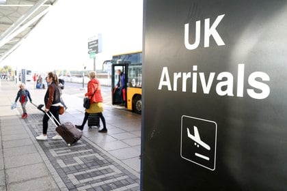 Passengers disembark buses next to an arrivals sign at London Stansted Airport, operated by Manchester Airports Group (MAG), in Stansted, U.K., on Friday, Oct. 28, 2016. Ryanair Holdings Plc, Europe's biggest discount carrier, said the expansion of U.K. capacity is welcome but that the government should also have backed the expansion of Gatwick and its own base at London Stansted to meet travel demand for decades to come.