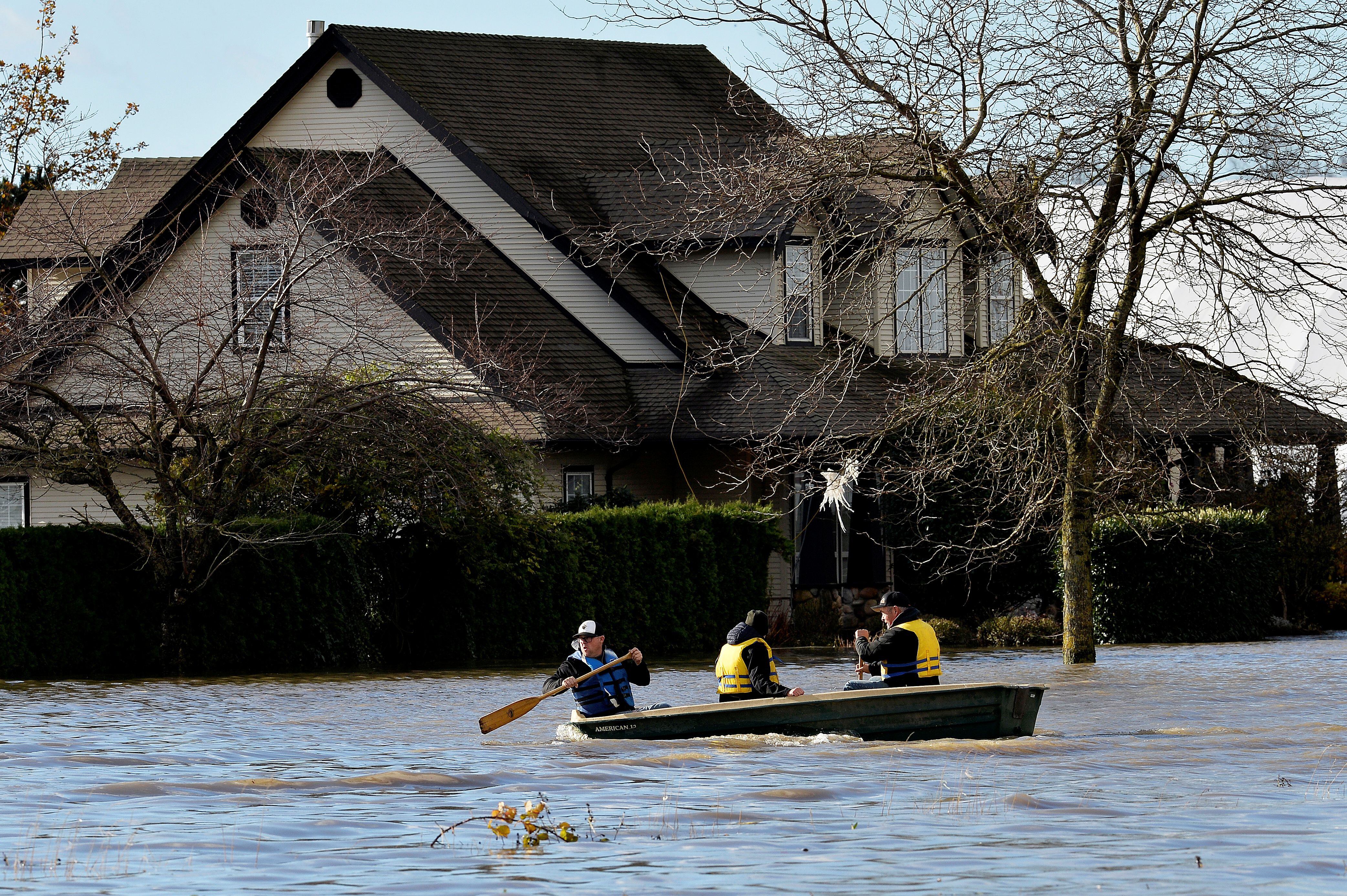 Where there was a street, three men travel in a boat to travel to Abbotsford (REUTERS / Jennifer Gauthier)