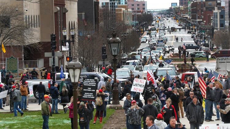 Manifestantes reunidos en las afueras del capitolio estatal de Michigan, protestando contra las medidas para evitar contagios de COVID-19 (AP Photo/ Paul Sancya)