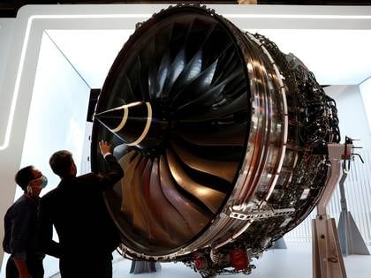 Personal de Rolls Royces usando mascarilla mientras inspeccionan un motor turboventilador de uso aeronáutico