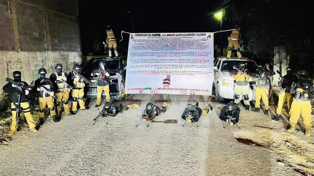 Presuntos sicarios posando junto a un narcomensaje
(Foto: Twitter/@TamCodigoRojo)