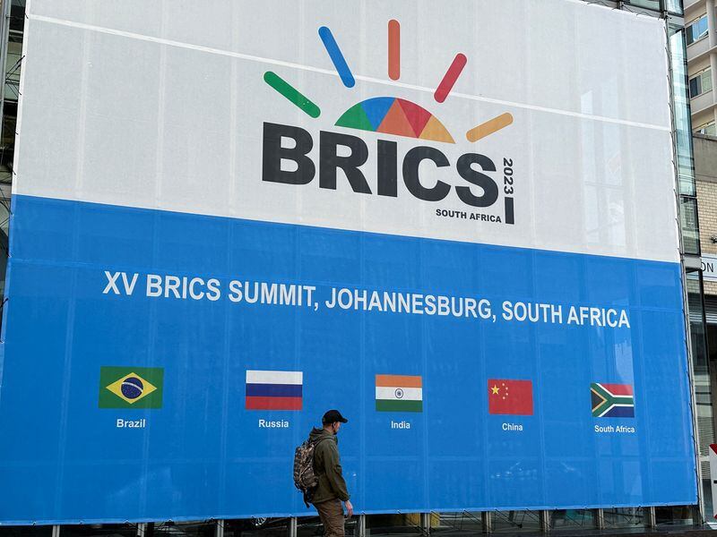 Una persona pasa por el Centro de Convenciones de Sandton, sede de la Cumbre BRICS, en Johannesburgo, Sudáfrica (Reuters)