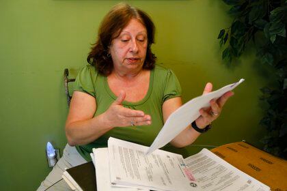 María Aurora Estévez, 64, revisa sus documentos legales en Miami (AFP)