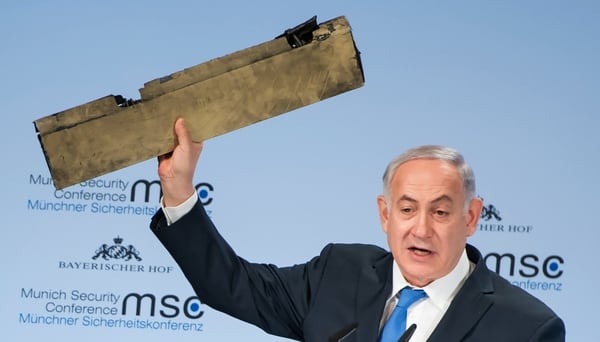 El primer ministro Benjamin Netanyahu muestra un pedazo del drone iraní derribado sobre cielo israelí (AFP)