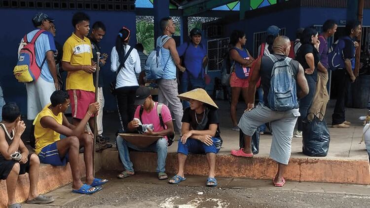 Mineros aguardan el transporte en la terminal de El Callao (Crédito: runrun.es)