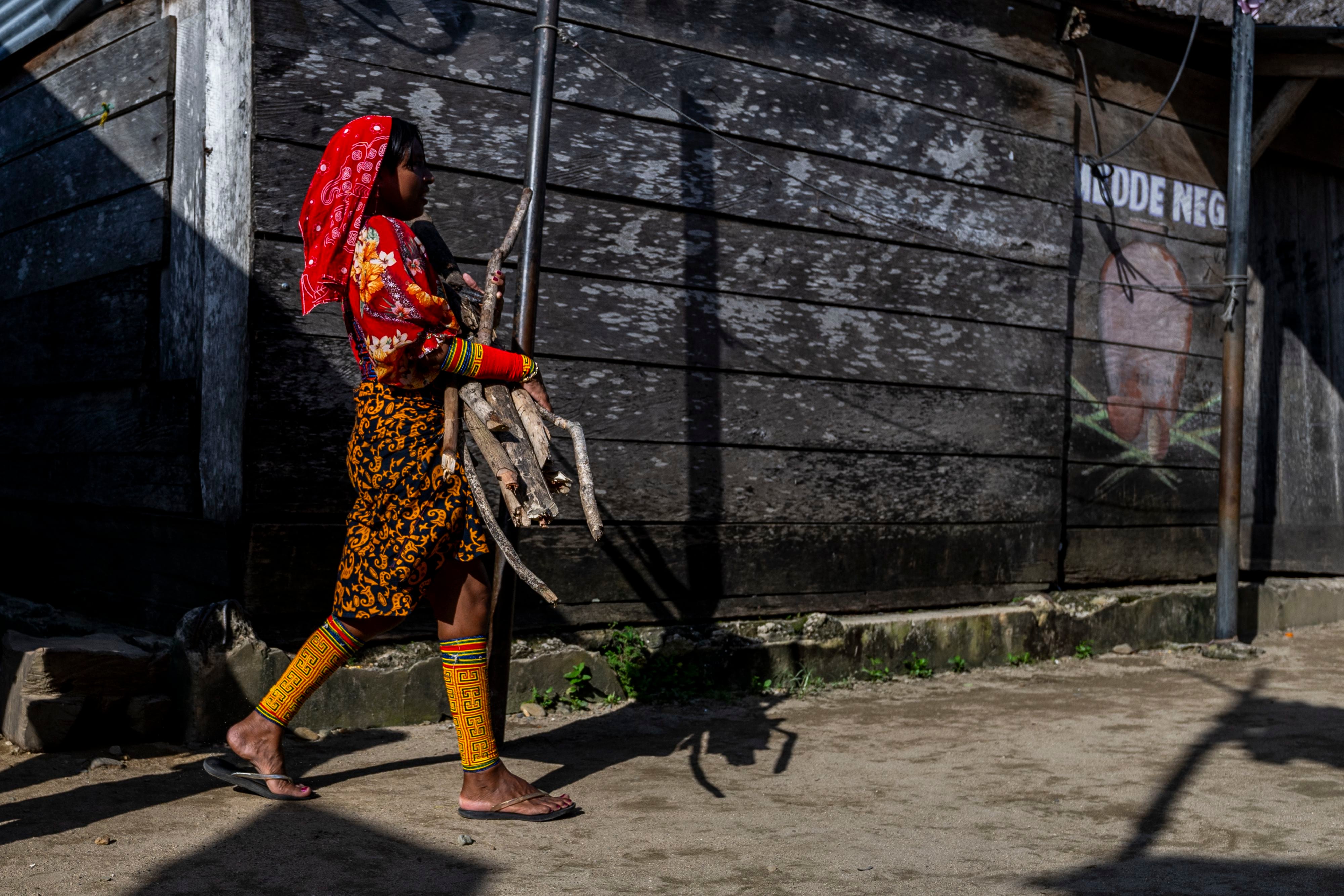 Una mujer indígena Guna carga leña en la isla de Carti Sugdupu, en la Comarca Indígena Guna Yala, Panamá, en el Mar Caribe, el 29 de agosto de 2023 (Foto de Luis ACOSTA/AFP)