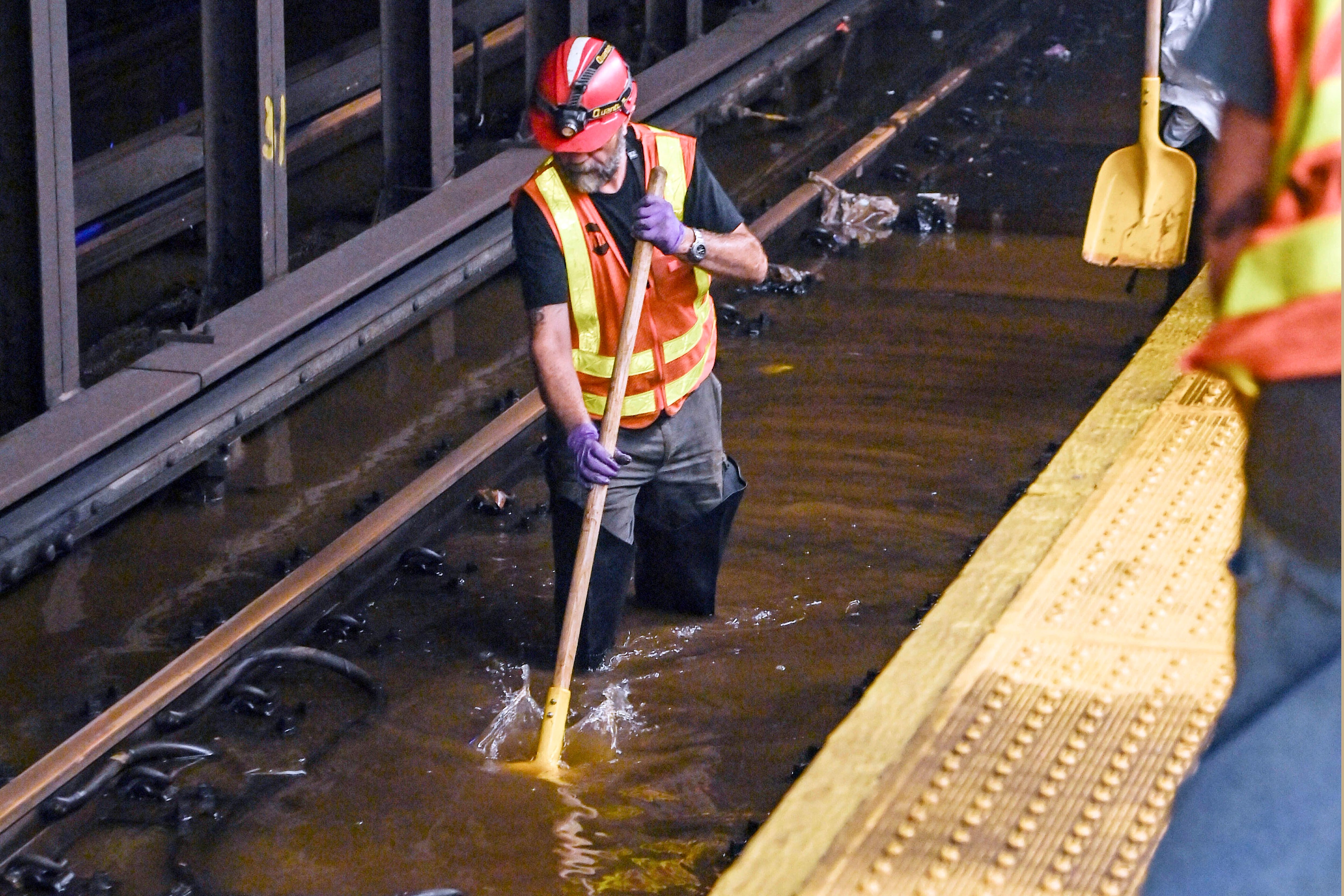 Un trabajador metido en las vías inundadas de la estación de metro de Times Square (Marc A. Hermann / MTA, via AP)