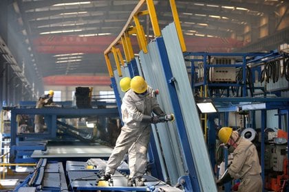 Las personas trabajan dentro de una fábrica de un parque industrial de construcción naval en un puerto de la ciudad de Qidong de Nantong, provincia de Jiangsu, China 16 de marzo de 2020. China Daily via REUTERS
