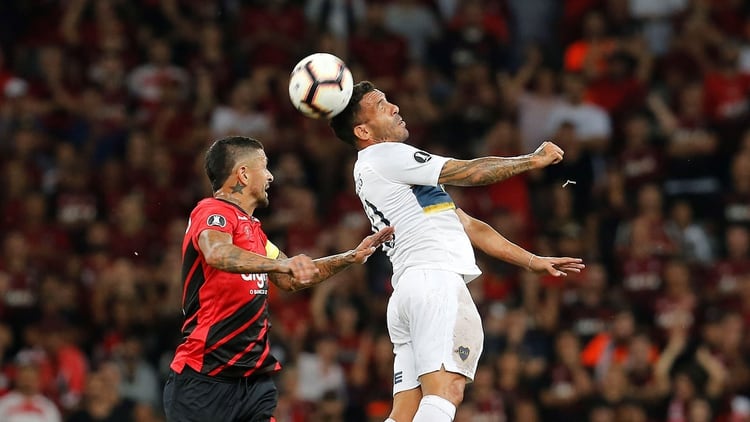 BRA101. CURITIBA (BRASIL), 02/04/2019.- Lucho González (i) del Atlético Paranaense disputa el balón con Carlos Tévez (d) del Boca Juniors este martes durante un partido de la Copa Libertadores 2019 disputado entre el Atlético Paranaense y el Boca Juniors, en el estadio Arena da Baixada, Curitiba (Brasil). EFE/Hedeson Alves