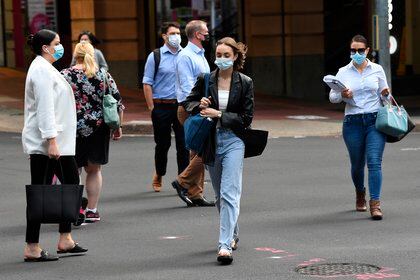 Las personas con máscaras protectoras se ven en el distrito central de negocios de Brisbane, Brisbane, Australia, 30 de marzo de 2021. EFE/EPA/DARREN/Archivo
