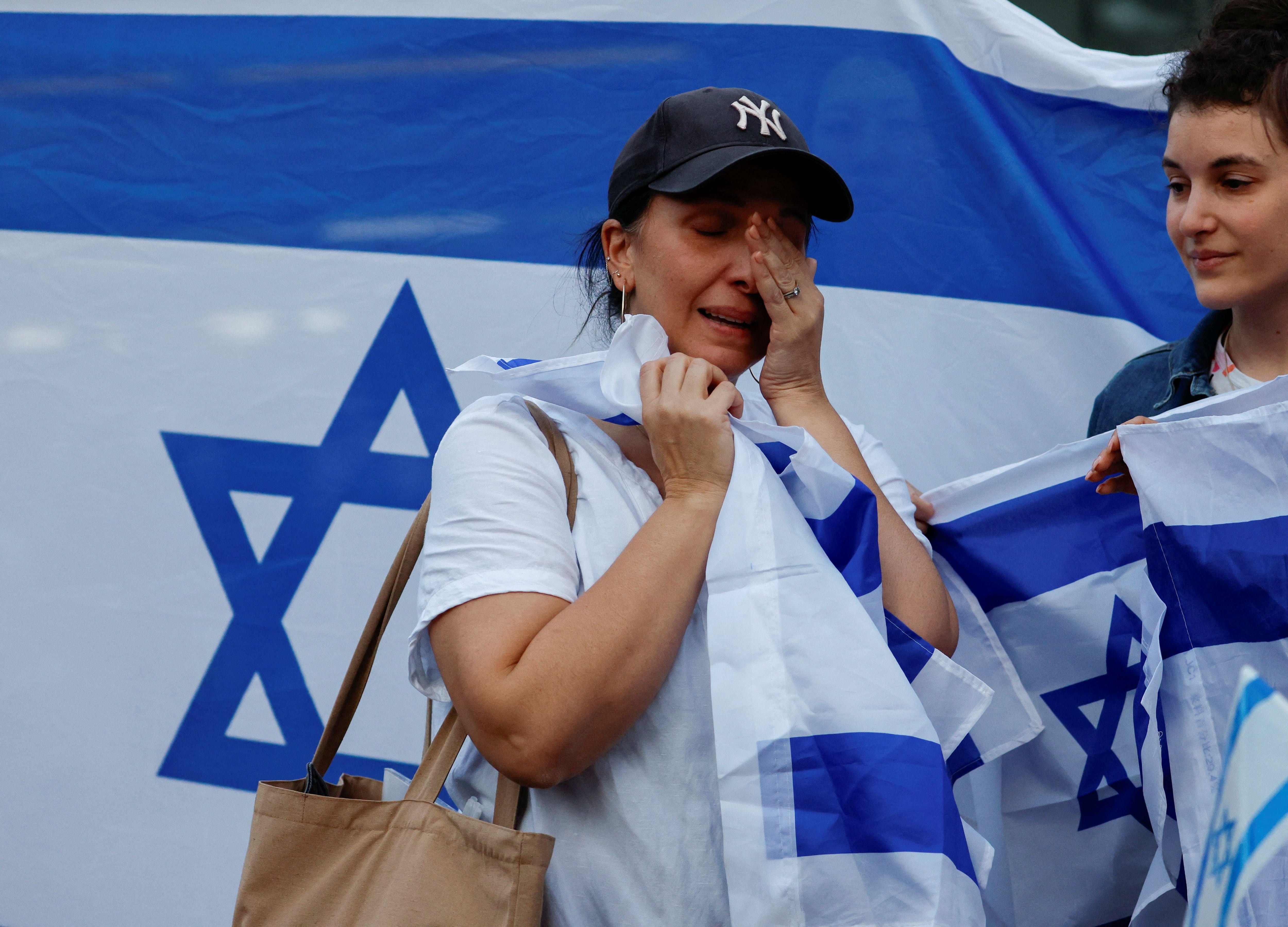 Una manifestante se seca las lágrimas mientras asiste a la concentración "Stand-with-Israel" exigiendo la liberación inmediata de todos los rehenes capturados durante el conflicto en curso con el grupo terrorista palestino Hamas, frente a la estación de Shibuya en Tokio, Japón 11 de octubre 2023.REUTERS/Issei Kato