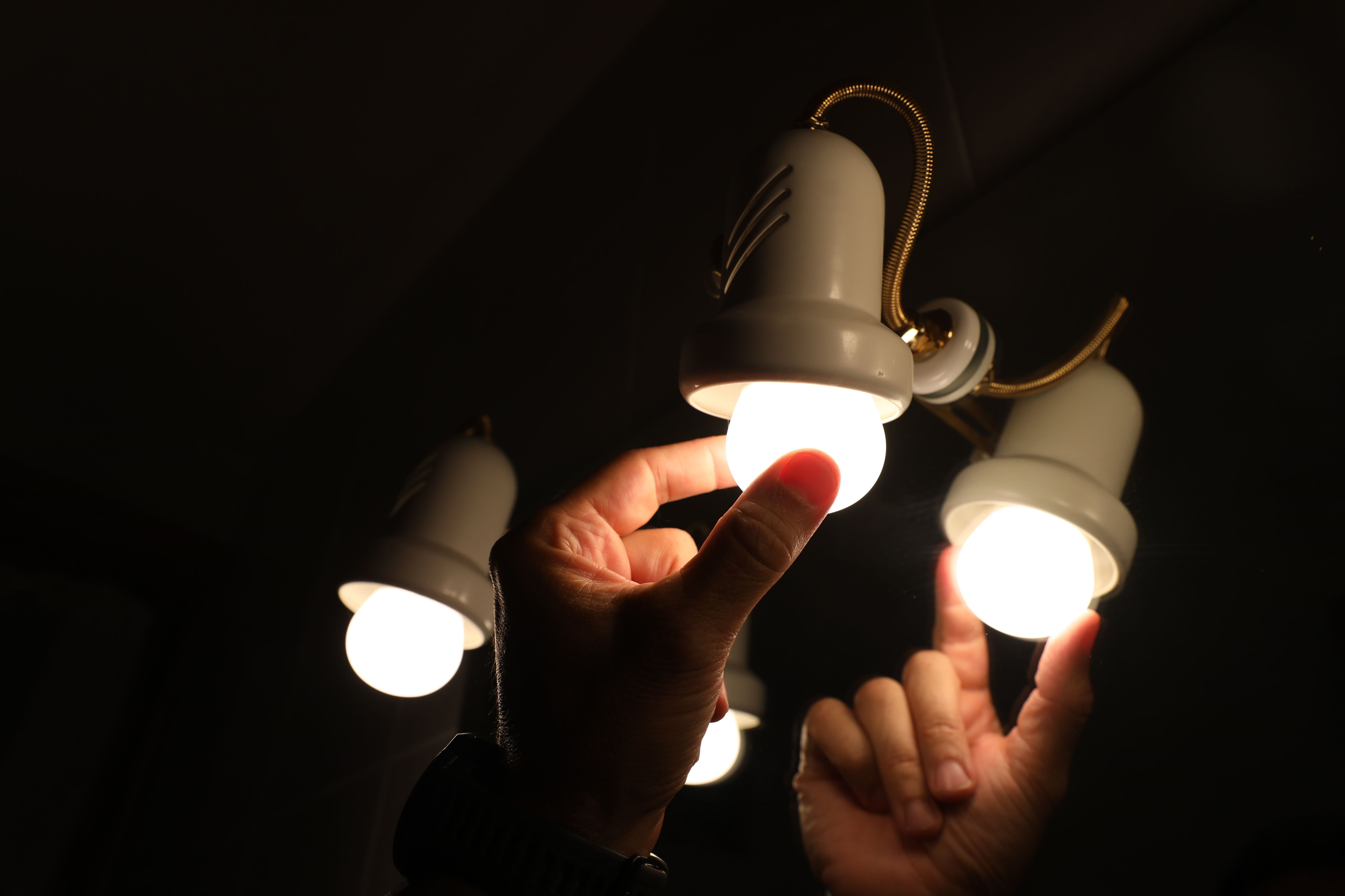 IMAGEN DE REFERENCIA: Una persona cambia la bombilla de una lámpara. Crédito: Marta Fernández - Europa Press