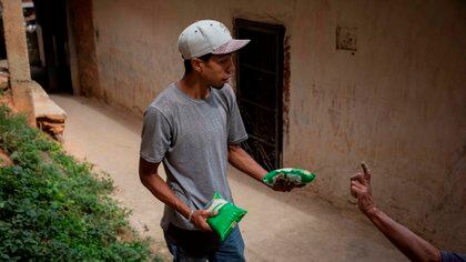 Bryan Blanco, de 27 años, carga kilos de arroz obtenidos mediante trueque con plátanos (EFE/RAYNER PEÑA R)