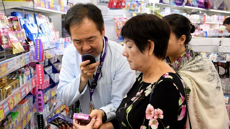 Un empleado de una tienda en Tokio ayuda a una compradora con la asistencia de un dispositivo portátil de traducción (Foto: Akio Kon/Bloomberg)