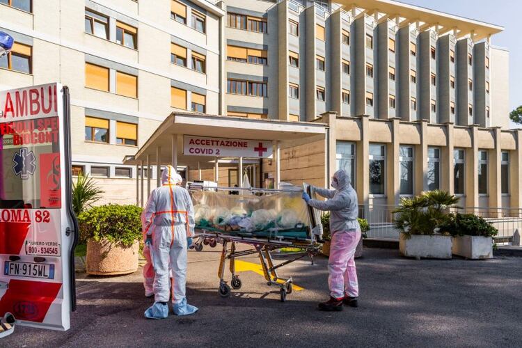 FOTO DE ARCHIVO: Un paciente con coronavirus llega en camilla al Hospital Colombo Covid, que ha sido asignado como uno de los nuevos hospitales de tratamiento de coronavirus en Roma, luego de ser trasladado por trabajadores médicos con trajes blancos protectores del Hospital Gemelli, en Roma, Italia. , 16 de marzo de 2020. (Gemelli a través de REUTERS)